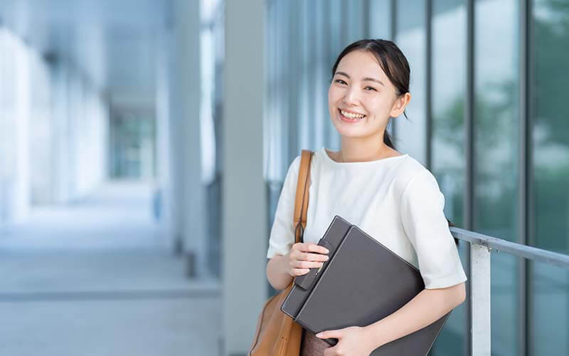 女性がパソコンを持っている画像